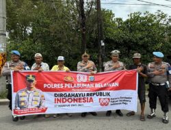 Polres Pelabuhan Belawan Bagikan Bendera Merah Putih di Simpang Pajak Baru